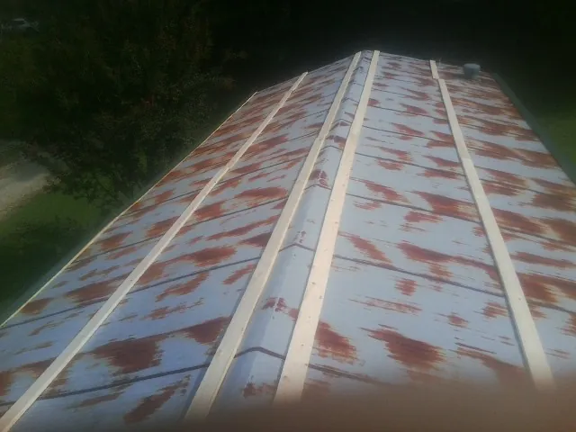 Rusted metal roof panels with new wood purlins before replacement — Storm Damage Roof Repair in Long Beach by Roofing Brothers