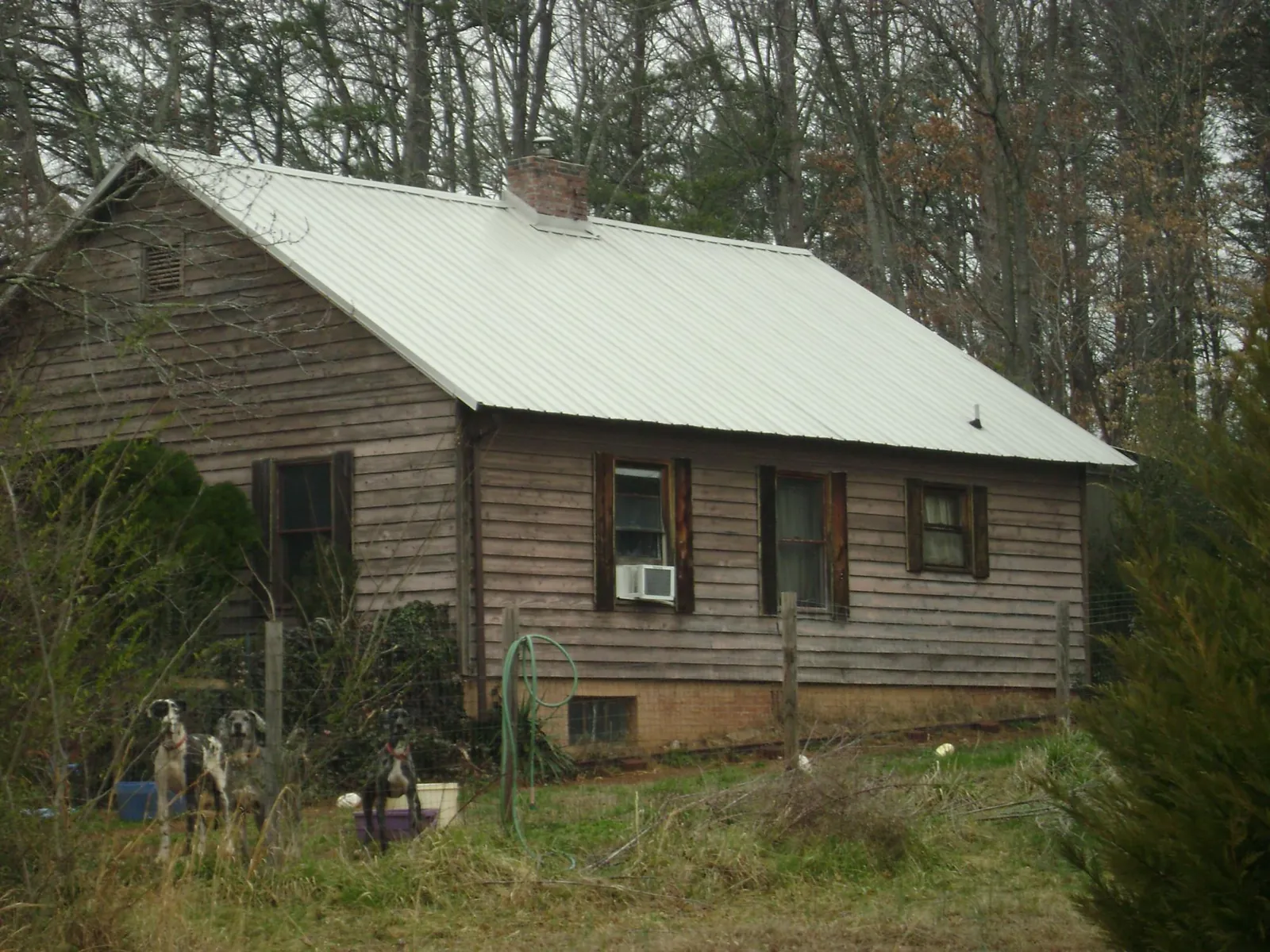 White metal roof on an old wood sided farmhouse, from a Metal Roof Installation job in Long Beach